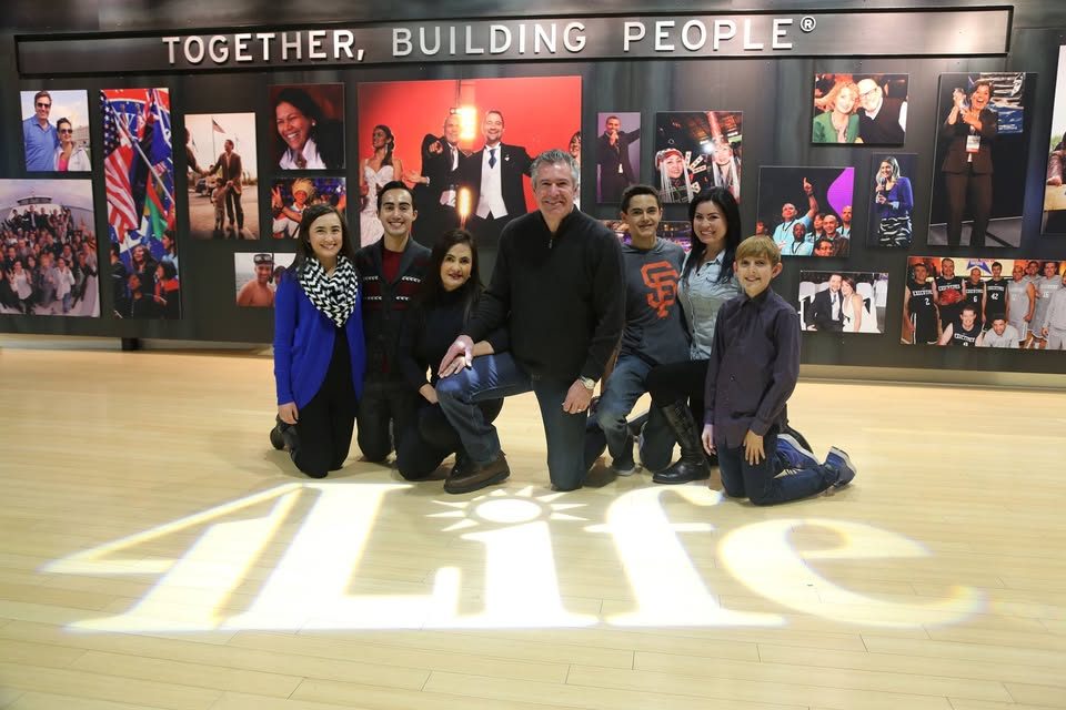 Dave Daughtrey with his family beneath a sign reading Together, Building People